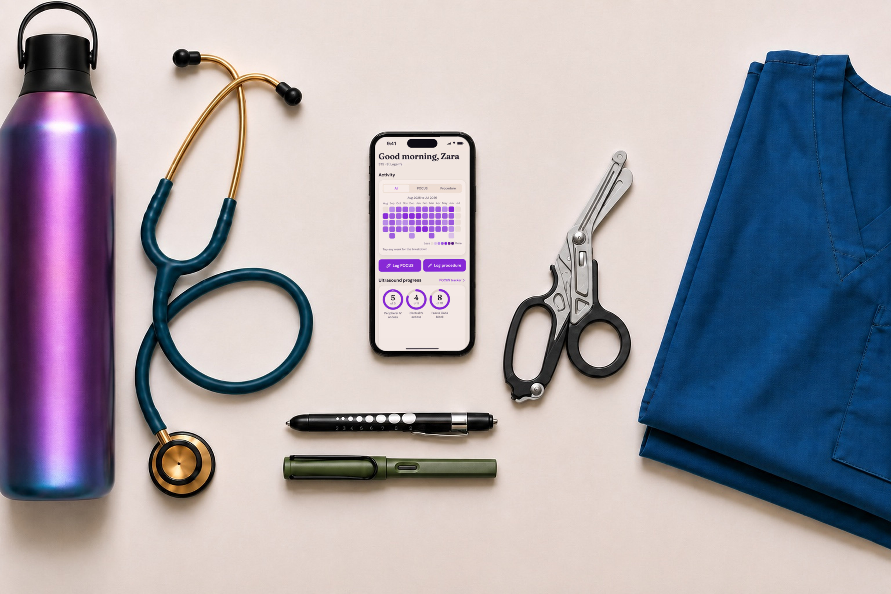 Emergency department shift essentials arranged around a phone running LogEM: stethoscope, trauma shears, pen torch, water bottle and scrubs